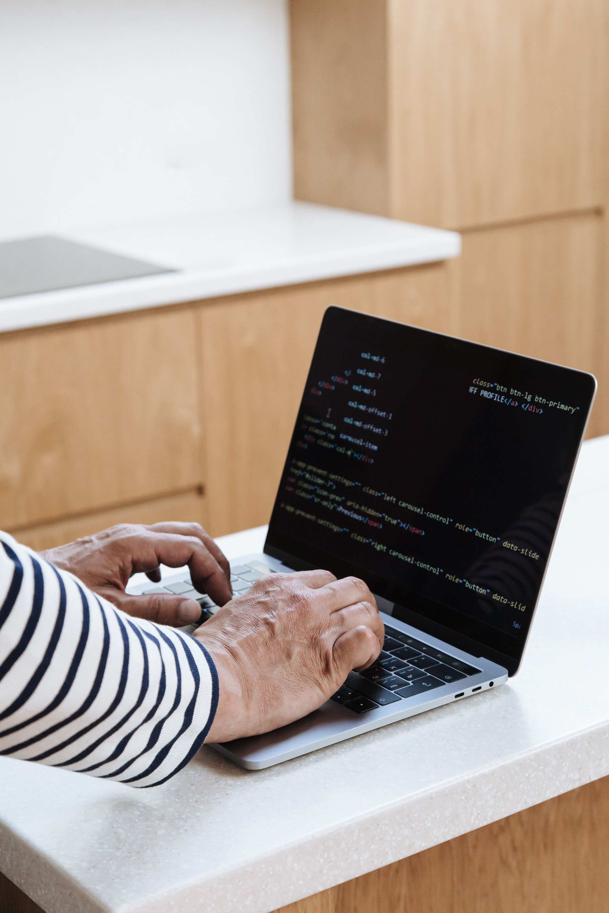 Developer typing on a laptop at a desk, close-up programming on a laptop